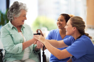 Jasmine Estates of Oklahoma City | Shot of a smiling female doctor and nurse talking with a senior woman in a wheelchair