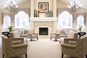 Jasmine Estates of Oklahoma City | Empty senior living home lobby with couches and a fireplace