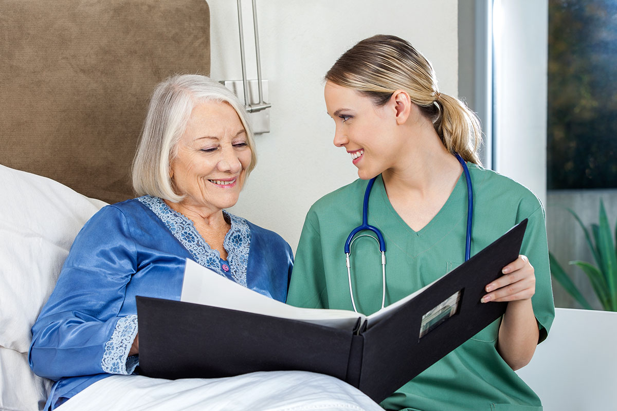 Jasmine Estates of Oklahoma City | Caregiver Showing Medical Reports To Senior Woman